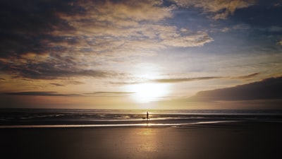 轮廓的人在海滩日落
